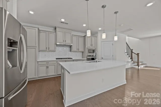 a kitchen with kitchen island a sink stainless steel appliances and cabinets