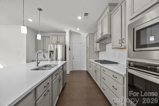 a kitchen with stainless steel appliances granite countertop a sink stove and refrigerator