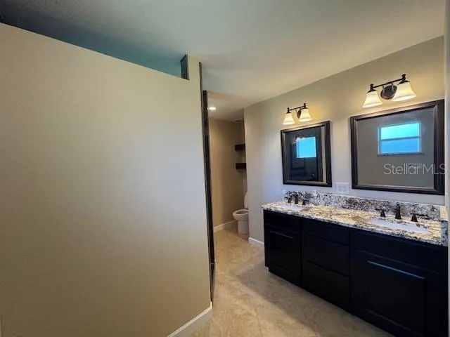 a bathroom with a double vanity sink and a mirror