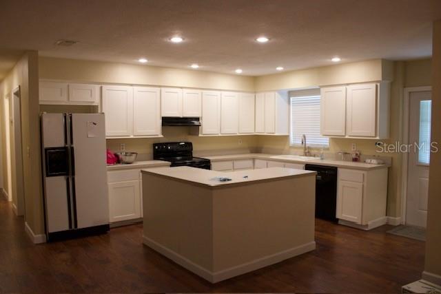 4825 Kimball Court East Lakeland, FL 33813 - Photo 4 of 26 a kitchen with kitchen island granite countertop a refrigerator a sink and a stove