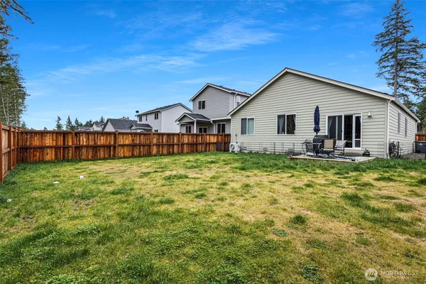 a view of a house with a big yard and large tree