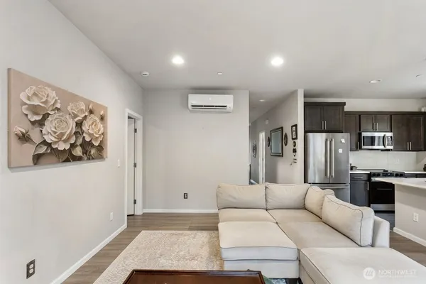 a living room with furniture and a refrigerator
