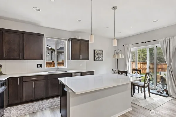 a kitchen with a sink a counter top space appliances and cabinets