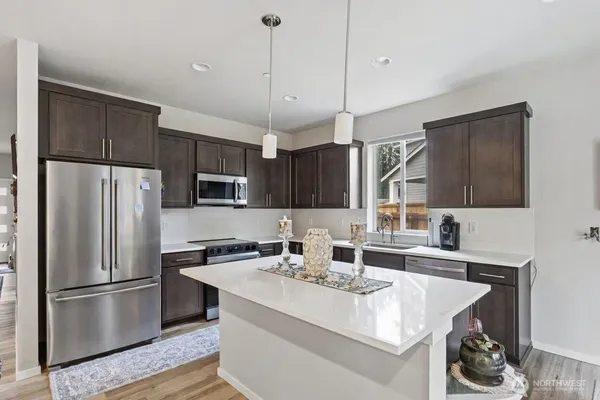 a kitchen with kitchen island a sink appliances and cabinets