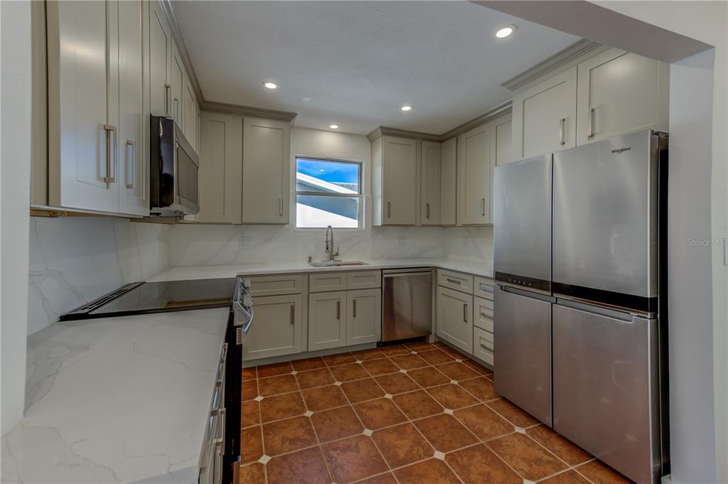 16245 Gulf Boulevard Redington Beach, FL 33708 - Photo 21 of 30 a kitchen with a refrigerator a sink and cabinets