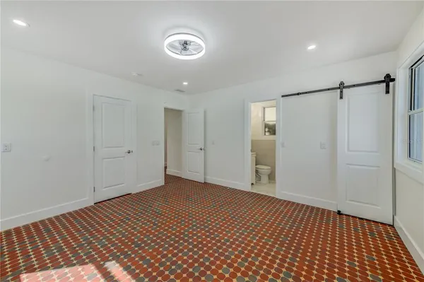 a view of an empty room with window and closet