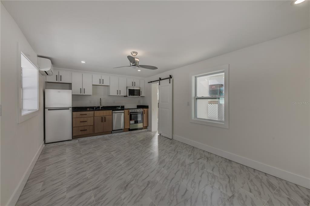 16245 Gulf Boulevard Redington Beach, FL 33708 - Photo 10 of 30 a kitchen with stainless steel appliances a refrigerator and wooden floor