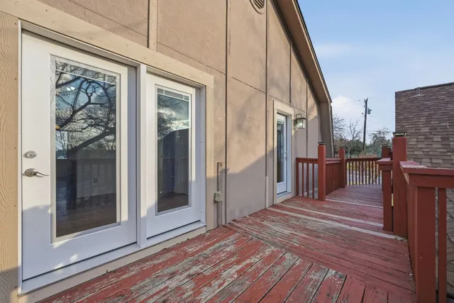 a view of a balcony with wooden floor and door