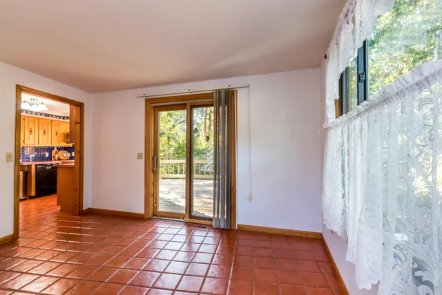 a dining room with wooden floor a chandelier a wooden table and chairs
