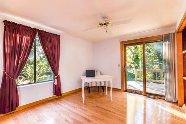 a dining room with furniture a large window and wooden floor
