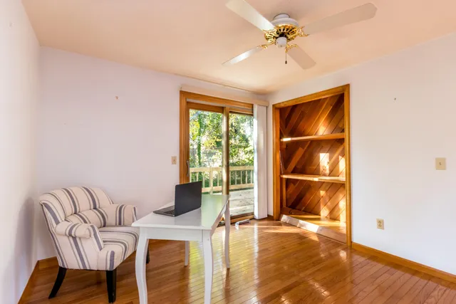 a view of a livingroom with wooden floor and an empty room
