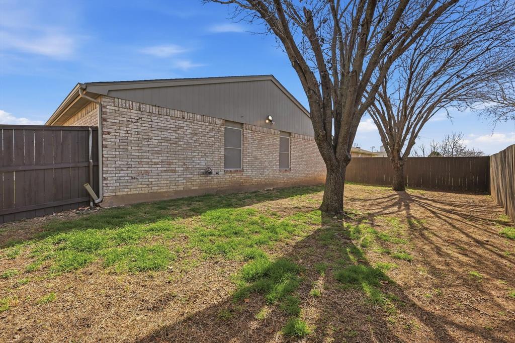 7733 Liz Lane Watauga, TX 76148 - Photo 24 of 27 View of property exterior with a fenced backyard and brick siding