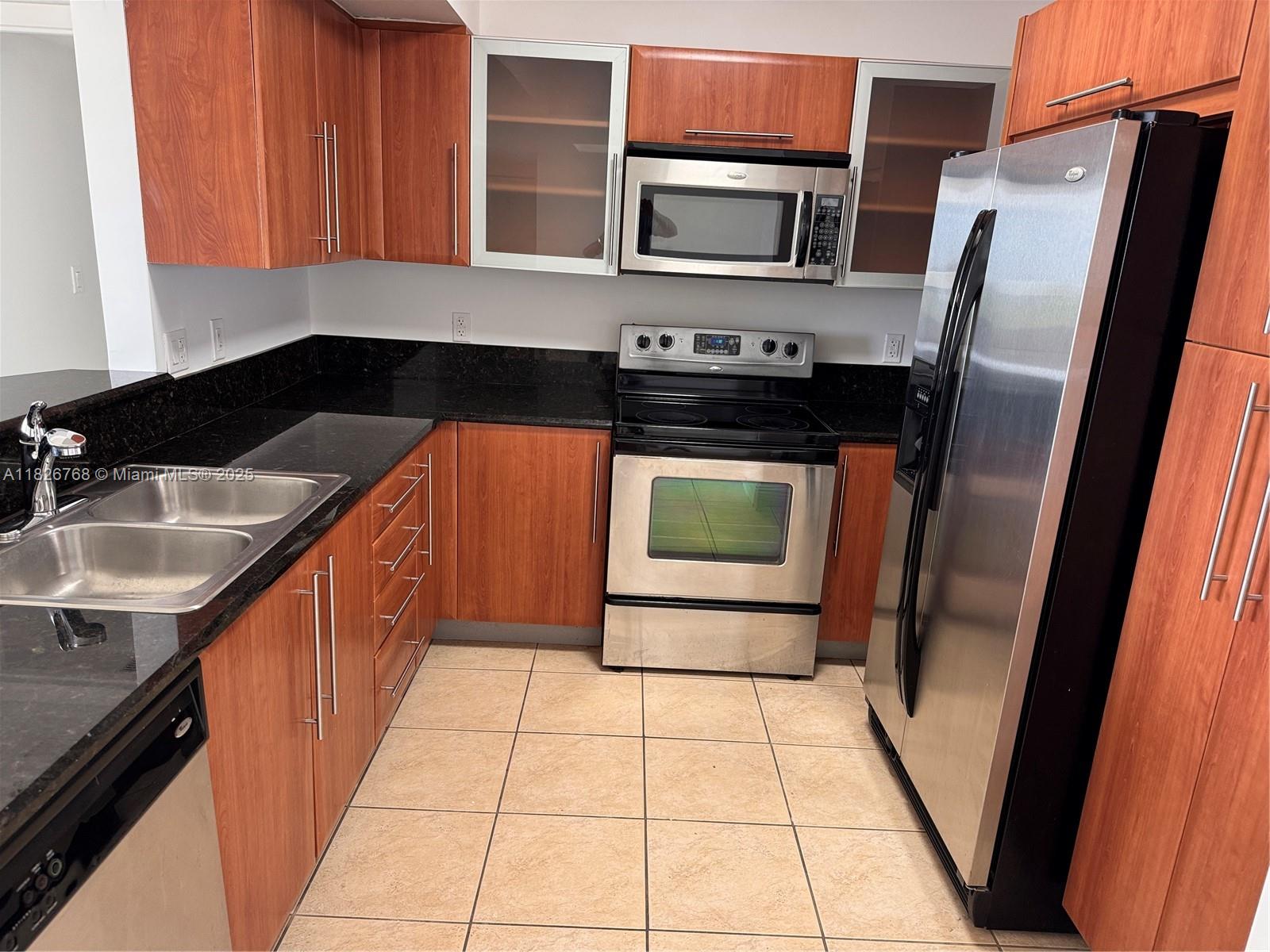 3232 Southwest 22nd Terrace, Unit 1008 Miami, FL 33145 - Photo 3 of 19 a kitchen with stainless steel appliances granite countertop a refrigerator and a sink