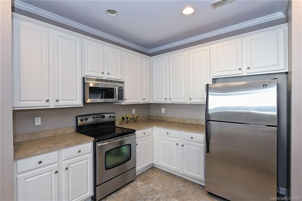 642 Brickdust Court Fort Mill, SC 29708 - Photo 11 of 24 a kitchen with white cabinets and white appliances