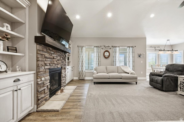 3123 East Riverdale Road Preston, ID 83263 - Photo 8 of 52 Family Room - Spacious living area featuring a stone-faced fireplace with a wood mantel, built-in shelving, white cabinetry, and wood-finish flooring