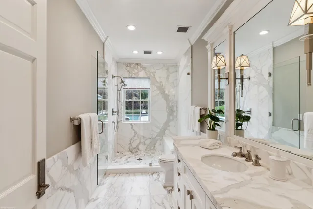 a bathroom with a granite countertop sink a mirror and a shower