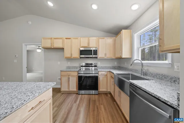 a kitchen with stainless steel appliances granite countertop a sink stove microwave and cabinets