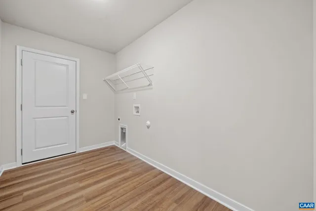 an empty room with a chandelier fan and windows