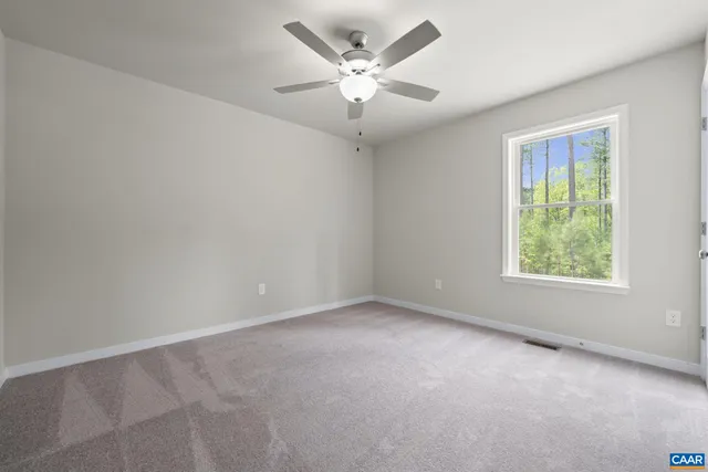 an empty room with fan and windows