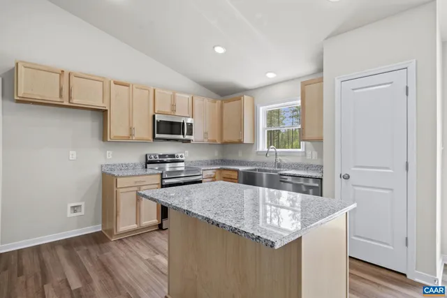 a kitchen with stainless steel appliances granite countertop a sink stove and microwave