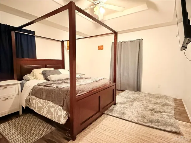 a bedroom with a bed and wooden floor