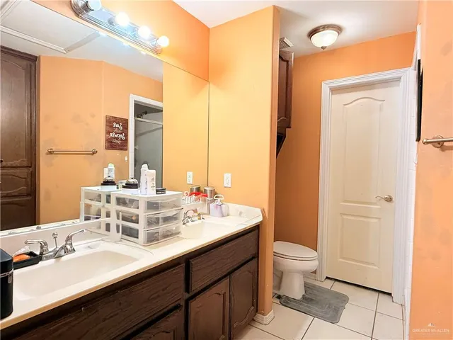 a bathroom with a double vanity sink mirror and toilet