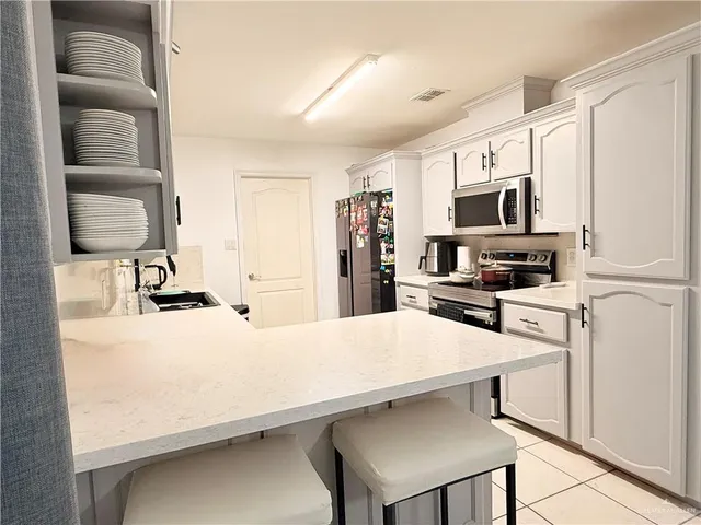 a kitchen with a sink a stove and chairs
