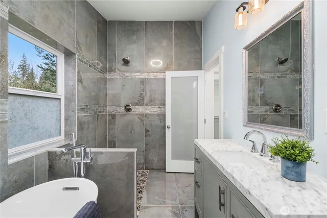 a bathroom with a granite countertop sink a toilet and shower