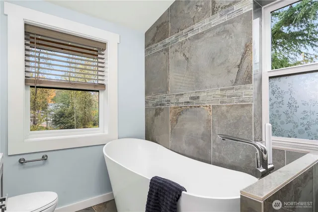 a bathroom with a sink a bathtub and a window