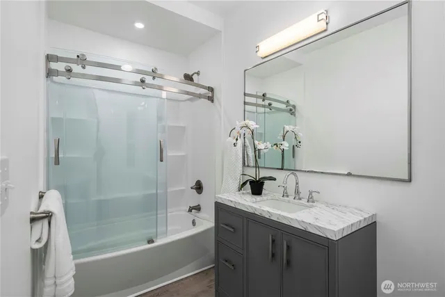a bathroom with a granite countertop sink mirror toilet and bathtub