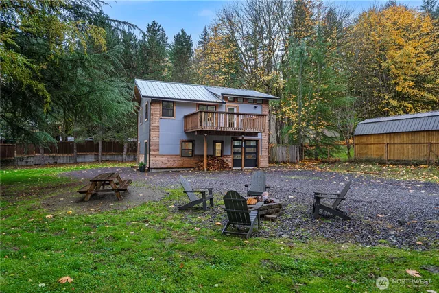 a view of a chair and table in backyard of the house