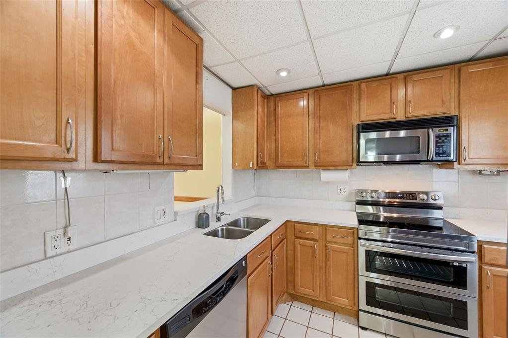 11485 Oakhurst Road, Unit 200208 Largo, FL 33774 - Photo 13 of 25 a kitchen with stainless steel appliances a stove a sink a microwave and cabinets