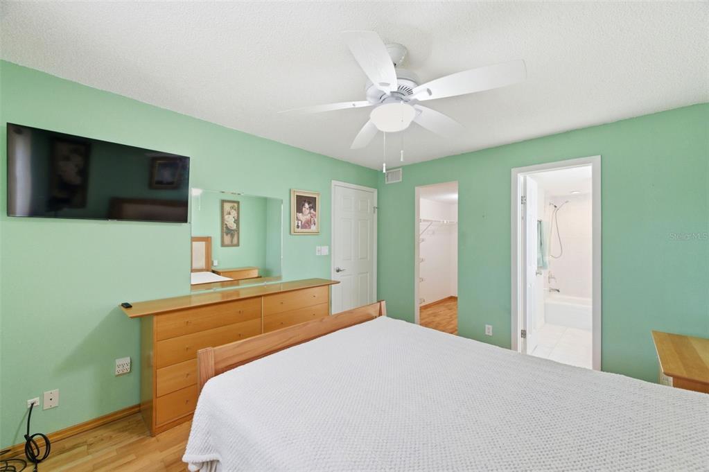 11485 Oakhurst Road, Unit 200208 Largo, FL 33774 - Photo 19 of 25 a bedroom with a bed and a flat screen tv
