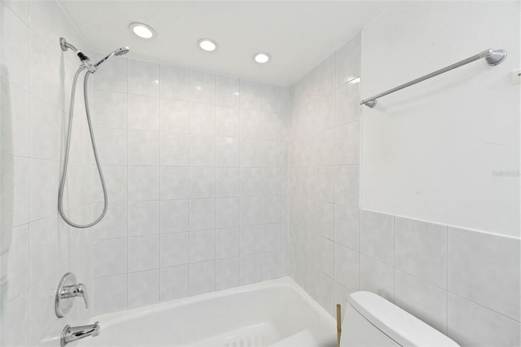 11485 Oakhurst Road, Unit 200208 Largo, FL 33774 - Photo 21 of 25 a bathroom with a bath tub with a glass door shower
