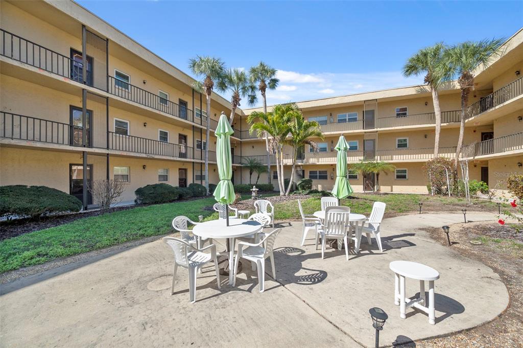 11485 Oakhurst Road, Unit 200208 Largo, FL 33774 - Photo 23 of 25 a view of a patio with couches table and chairs and potted plants