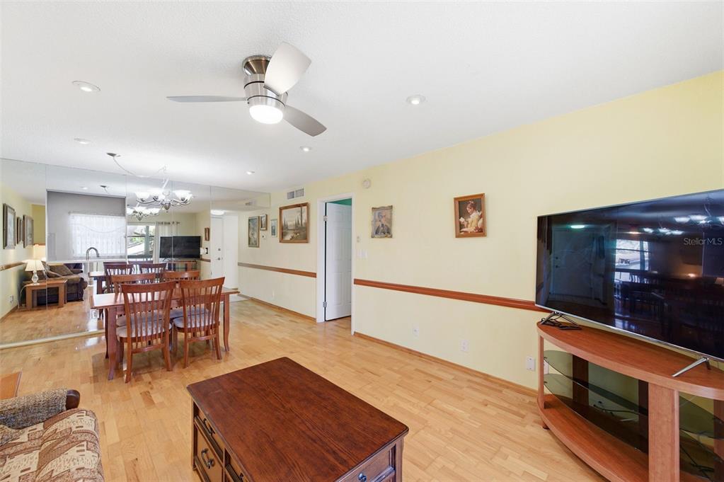 11485 Oakhurst Road, Unit 200208 Largo, FL 33774 - Photo 9 of 25 a living room with furniture a wooden floor and chandelier