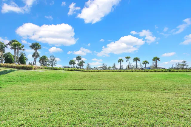 a front view of a house with a yard and potted plants