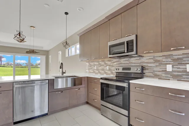 a kitchen with stainless steel appliances granite countertop a stove a sink and a microwave