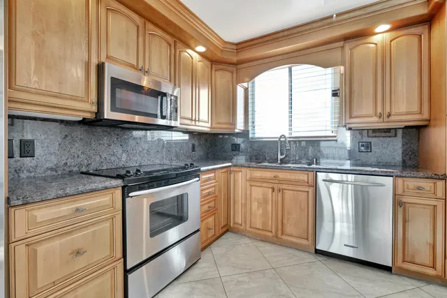 a kitchen with granite countertop a sink and a window