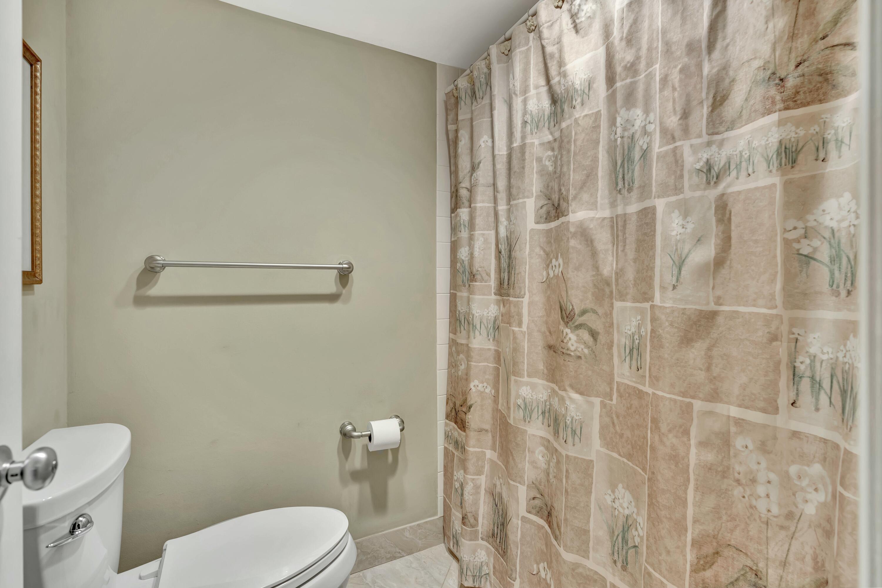 100 Ocean Trail Way, Unit 1201 Jupiter, FL 33477 - Photo 26 of 61 a white toilet sitting next to a shower curtain
