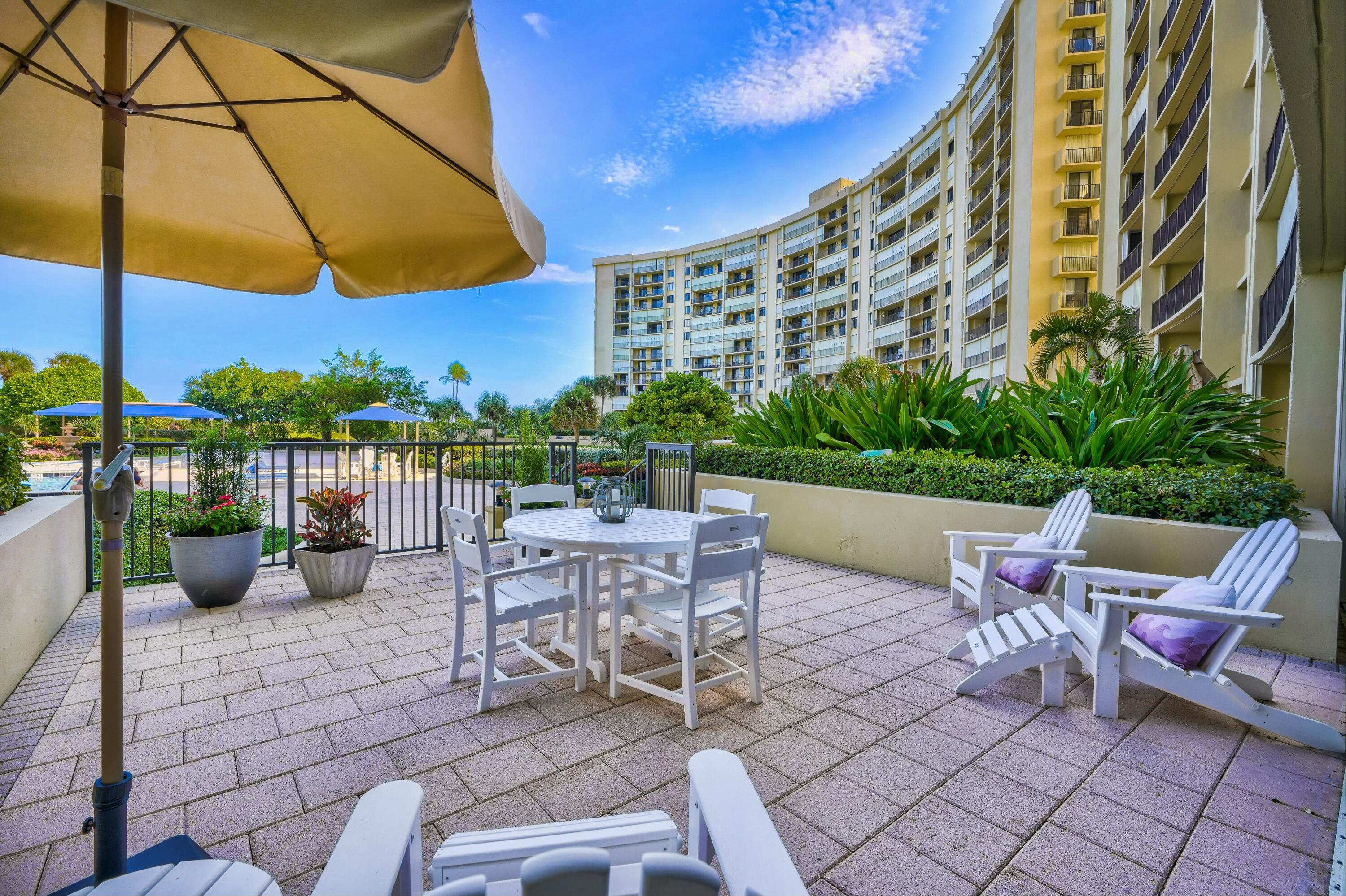 100 Ocean Trail Way, Unit 1201 Jupiter, FL 33477 - Photo 41 of 61 a view of a patio with a table and chairs under an umbrella