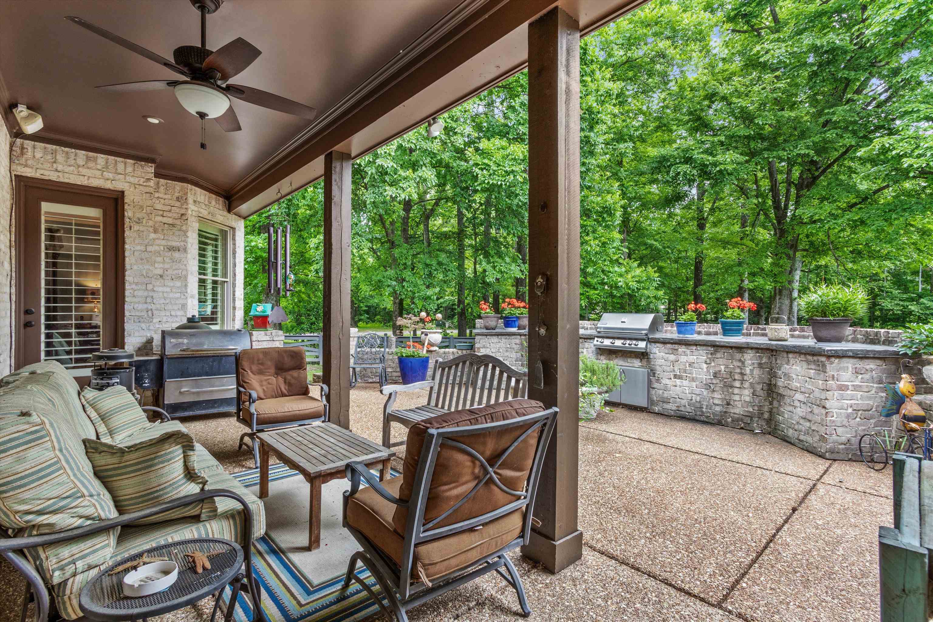 150 Ridgecrest Drive Arlington, TN 38002 - Photo 33 of 40 Covered patio featuring a ceiling fan, exposed aggregate concrete flooring, and a whitewashed brick exterior wall