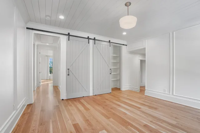 a view of a room with wooden floor and white walls