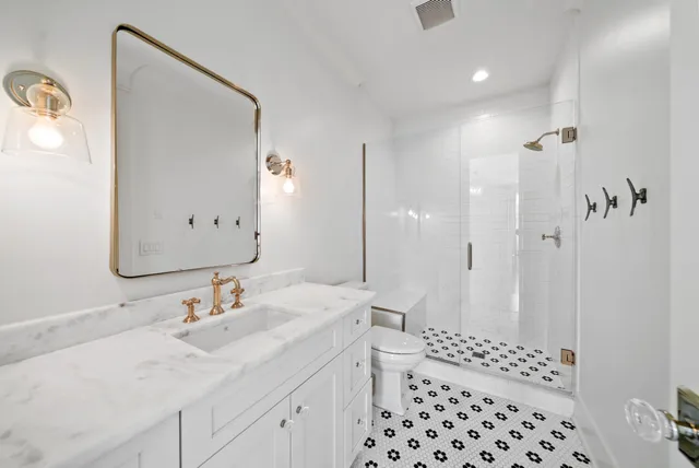 a bathroom with a sink a toilet and shower