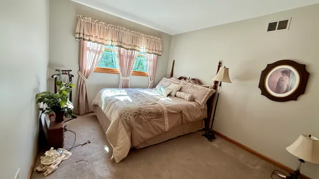 a bed sitting in a bedroom next to a window