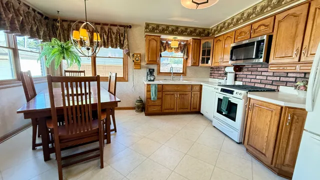 a kitchen with stainless steel appliances granite countertop a stove top oven a sink dishwasher and a microwave