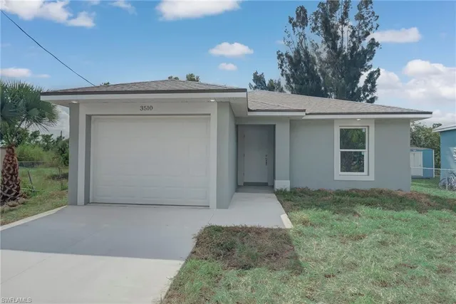 a view of a house with a yard and garage