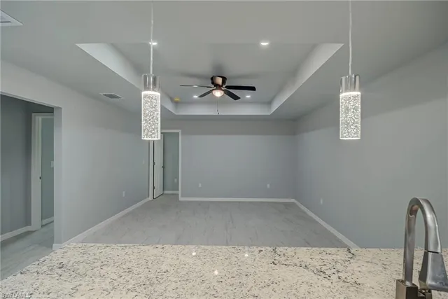 an empty room with wooden floor and ceiling fan