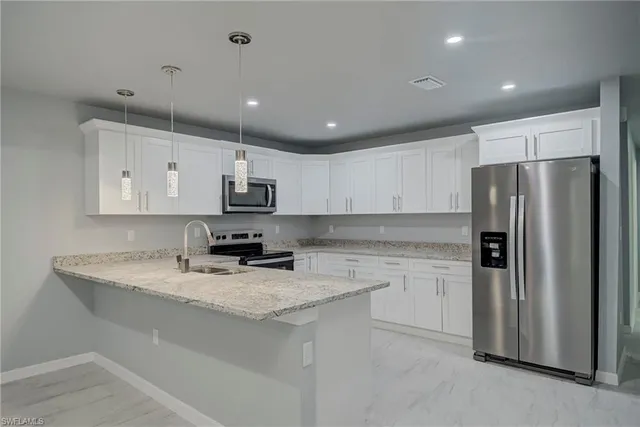 a kitchen with kitchen island granite countertop stainless steel appliances and refrigerator
