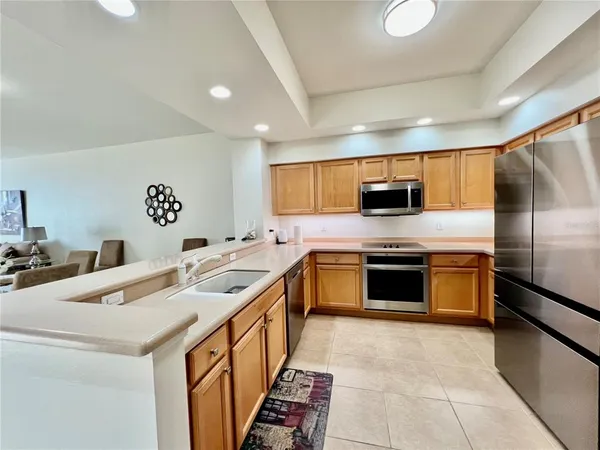 a kitchen that has a sink a counter space and a refrigerator